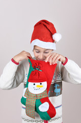 Young boy looking inside Christmas stocking