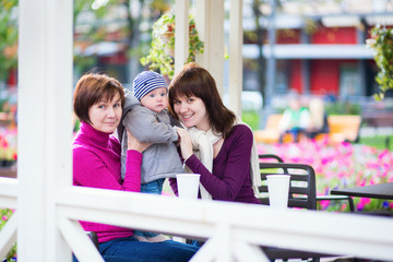 Grandmother, mother and little son in cafe