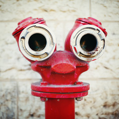 Red old fire hydrant on a street. Smiley face.