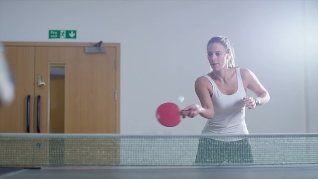 Slow motion clip of a pretty woman playing table tennis
