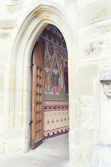 Fototapeta na wymiar open wood door revealing painted wall in Putna Monastery, Bucovi