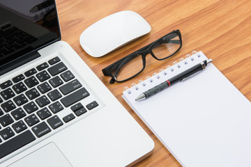 Blank business laptop, mouse, pen, note and glasses