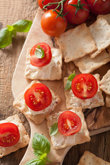 crackers with soft cheese and tomatoes. healthy appetizer