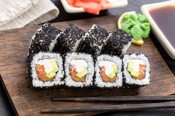 Salmon sushi roll covered with sesame