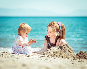 little girl  builds a tower of sand