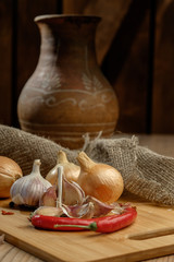 Onions, chili and garlic on a wooden table.