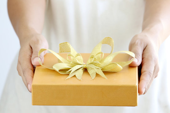 Woman holding a gold gift box