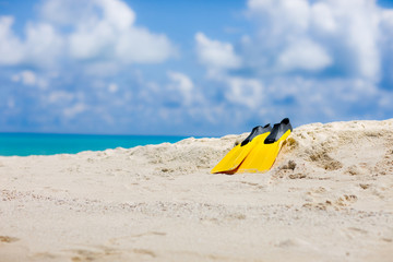 Yellow flippers on Maldivian beach in the Indian ocean