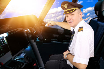 Smiling and cheerful pilot in the cockpit of an airliner © ambrozinio