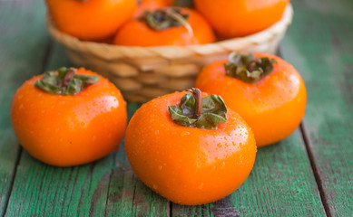 ripe persimmons in a wicker basket