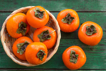 ripe persimmons in a wicker basket