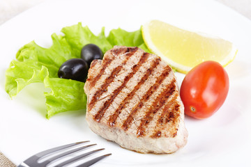 Grilled steak on white plate closeup