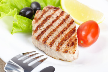 Grilled steak on white plate closeup