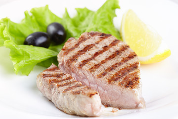 Grilled steak on white plate closeup