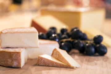Close up cheese with grapes on a cutting board