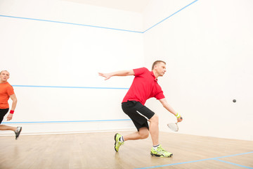 Two men playing match of squash.