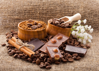Coffee beans in wooden bowl on burlap tablecloth, rustic style