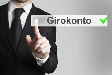 Geschäftsmann in Anzug drückt touchscreen Knopf Girokonto