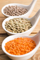 Three kinds of lentil in bowls - red lentil, green lentil and br