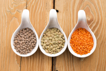 Three kinds of lentil in bowls - red lentil, green lentil and br