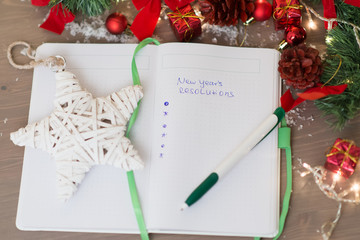 New year's resolutions written on a notepad with a star and new