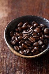Dark coffee beans in a ceramic dish