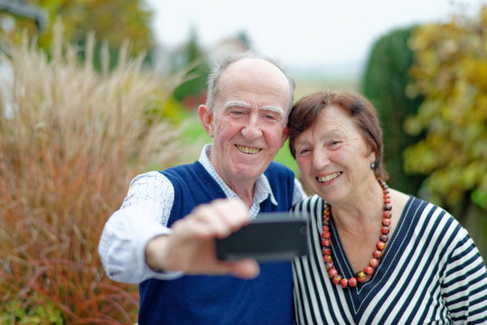 Happy senior couple bonding to each other and making selfie