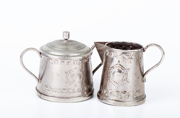 old sugar bowl with lid and an old coffee pot with spots of rust
