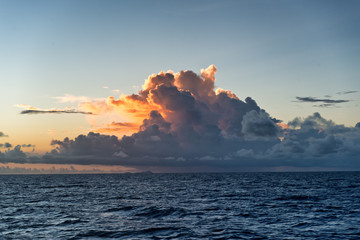 Colorful orange sunset behind cumulonimbus clouds