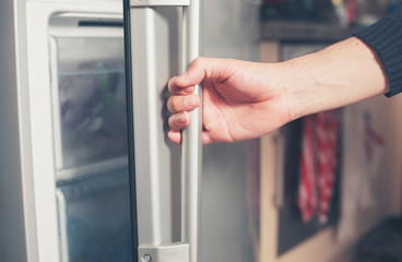 Hand opening freezer door - obrazy, fototapety, plakaty