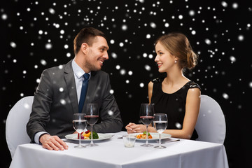 smiling couple eating main course at restaurant