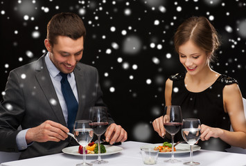 smiling couple eating main course at restaurant