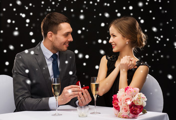 smiling couple with red gift box at restaurant