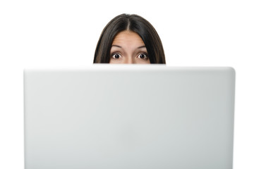 Frau schaut überrascht hinter ihrem Computer hervor