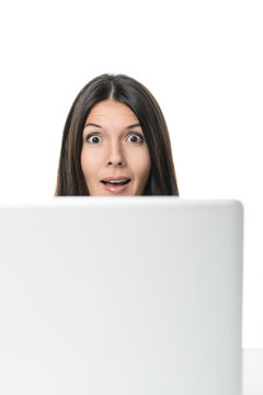 Frau schaut überrascht hinter ihrem Computer hervor