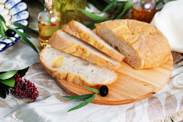 Ciabatta in still life on blackboard with olives and olive oil