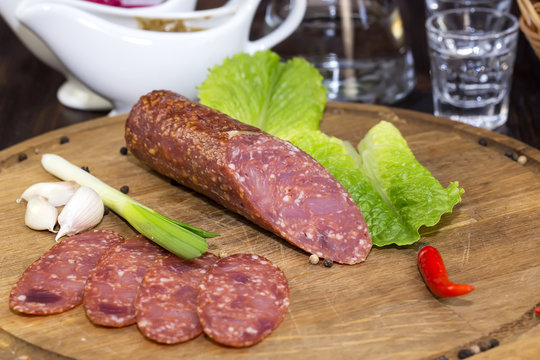 sausages on a wooden plate with vegetables in a restaurant