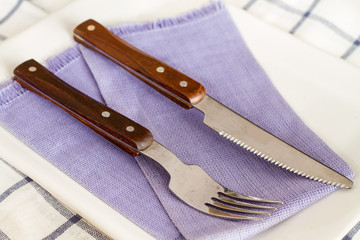 spoons and knives laid out on a plate.