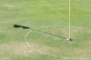 Obraz premium golf hole on green grass with shadow flag