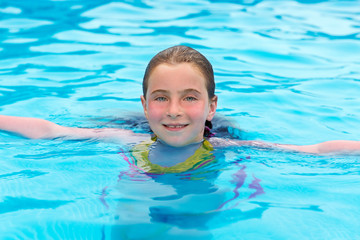Fototapeta na wymiar Blond girl swimming in the pool with red cheeks