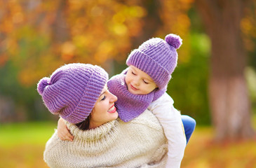 happy mother and son playing in autumn park