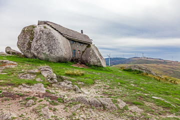 House built between huge rocks on top of a mountain