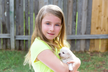 Blond kid girl with puppy pet chihuahua playing