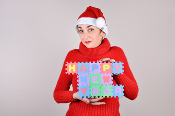 Woman in red with Santa hat holding a Happy New Year sign