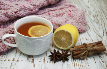 Cup of hot tea with lemon and scarf