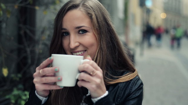Young happy attractive woman drinking coffee in cafe