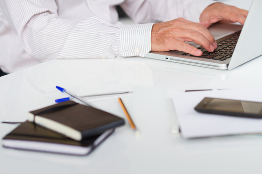 Man inputing data on laptop with shallow dof