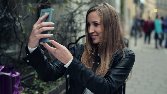 Woman taking selfie photo in cafe with smartphone