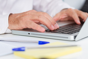 Businessman taking notes with laptop