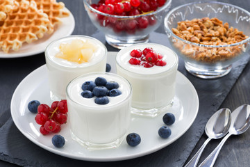 assortment yogurt with fresh berries and waffles for breakfast
